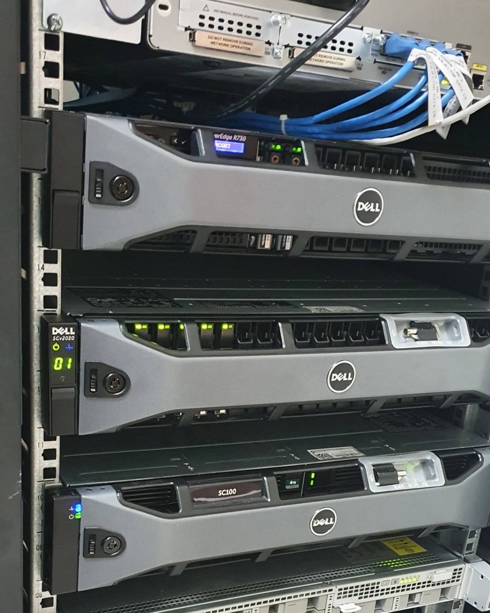 Rack-mounted Dell servers and storage arrays in a business server cabinet.